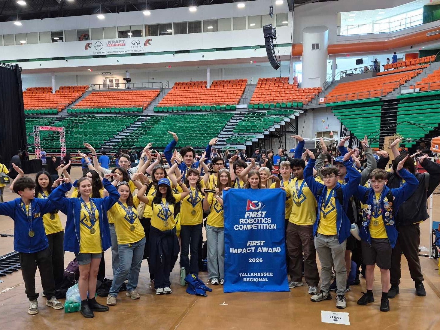 Team Voltage students holding the 2026 FIRST Impact Award banner at Tallahassee Regional